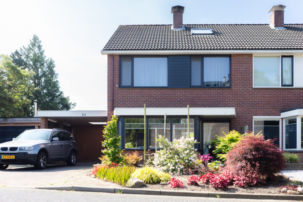 Volledige voorgevel van een woning in Oldenzaal met kunststof kozijnen en gevelbekleding in RAL 7016