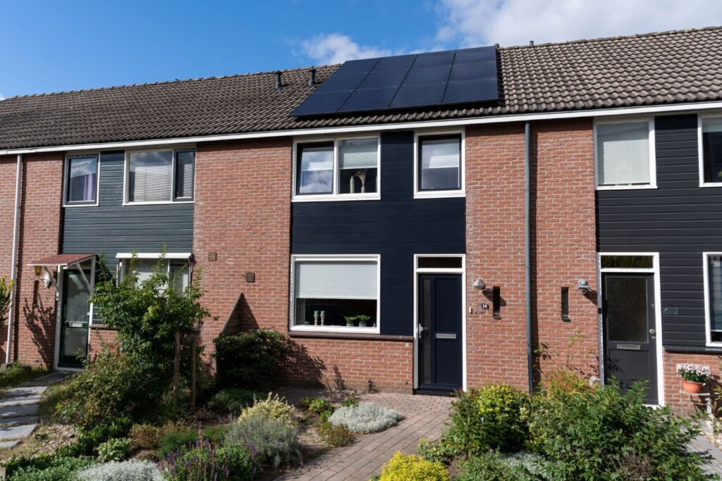 Voorgevel van een moderne tussenwoning met kunststof kozijnen in RAL 9010 en draaideelkozijnen in stijlvol RAL 5004, afgewerkt met strakke Keralit-gevelbekleding.
